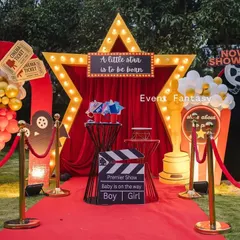 Announcing the arrival of a little star with a 'Lights! Camera! Baby!' themed baby shower. This fun, glamorous setup includes a red carpet entrance, a marquee star, and movie-themed props, making the parents-to-be feel like true celebrities.