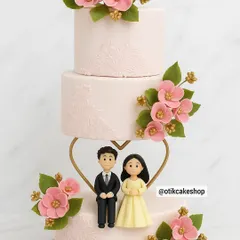 For a truly special union, we designed this elegant three-tiered wedding cake. Adorned with delicate pink sugar flowers and a custom couple figurine, it’s a beautiful centerpiece for celebrating love.
