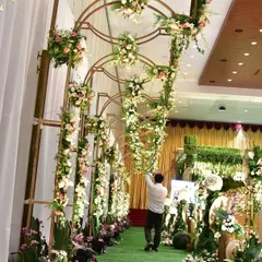 An elegant floral archway leading into the main wedding hall. This creates a beautiful and welcoming entrance for guests, setting the tone for the grand celebration inside.