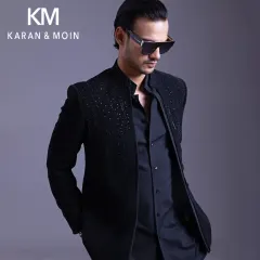 This open-front bandhgala, layered over a tonal kurta and trousers, is a contemporary and versatile look. The subtle crystal work on the shoulders adds a touch of evening glamour without being overt.