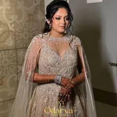 A full-length view of the bride in her breathtaking Sangeet gown with a sheer cape. The makeup and hair are styled to complement the modern, ethereal vibe of her outfit.