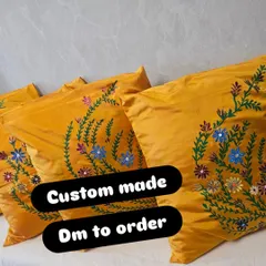 A close-up of the custom-made yellow silk cushion covers with hand-painted floral designs. These are perfect for adding a pop of color and a personal touch to your sofa or bed.
