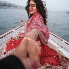 The iconic "follow me to" pose on a boat in Varanasi. This shot is all about connection, leading your partner into a new life against a sacred backdrop.