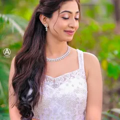 A serene and beautiful bridal portrait. This close-up highlights the delicate beading on the bodice of the white gown and the bride's elegant hair and makeup.
