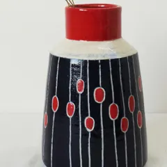 A closer look at one of the Dew Drops vases. The contrast between the matte white, glossy red, and deep indigo makes it a visually striking piece for holding dried or fresh flowers.