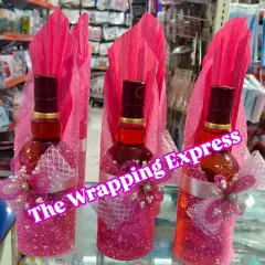 Elegant gift wrapping for Chivas Regal whisky bottles, perfect for Diwali gifting. The bottles are decorated with pink glitter, ribbons, and pearl details.