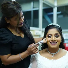 Here I am, adding the finishing touches. For this Christian bridal look, I used a soft-bristle brush to apply a light layer of powder, ensuring her makeup stays flawless all day.
