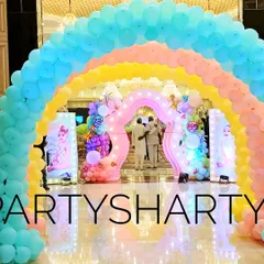 A multi-layered rainbow balloon arch creates a stunning and colorful entrance for a Candyland or rainbow-themed party.