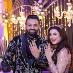 The moment it becomes official. We captured the pure happiness of this couple as they proudly displayed their engagement rings, smiling brightly against a backdrop of elegant chandeliers and floral decor.