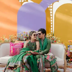 The couple's seating at their Ooty haldi was a vibe. A simple sofa set against a backdrop of colorful arches and florals for that perfect photo op.