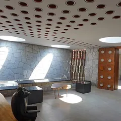 The resort's reception area features local stone walls and circular skylights, celebrating natural materials and allowing sunlight to animate the interior throughout the day.