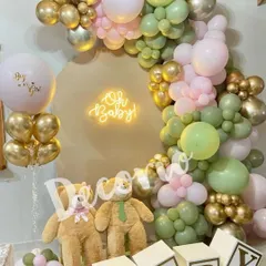 This gender reveal setup uses an earthy color palette of sage green and dusty pink with pops of gold. The two teddy bears and 'BABY' blocks add a playful touch to the "Oh Baby" theme.
