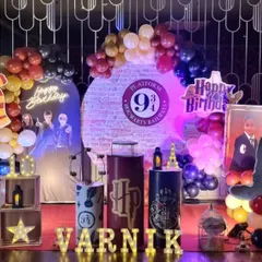 A magical Harry Potter themed birthday party setup. This detailed arrangement includes a "Platform 9 3/4" backdrop, house color balloon garlands, character posters, and iconic props like the Sorting Hat and Hedwig the owl to transport guests to the wizarding world.