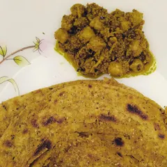 My Ghissu Aam Chana Achaar served with a delicious Lachcha Paratha. This pickle is a unique mix of grated raw mango and boiled chickpeas, creating a lip-smacking flavour that pairs perfectly with any Indian bread.