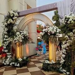 Elegance is in the details. This grand entrance arch, crafted with lush white florals and subtle gold accents, was designed to provide a luxurious and welcoming first impression for a high-end corporate milestone celebration.