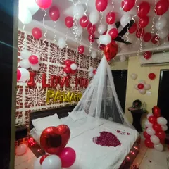 A simple yet beautiful way to say 'I Love You'. This room is filled with red and white balloons, a custom foil message, a net canopy, and a heart of rose petals on the bed, making it perfect for proposals or anniversaries.
