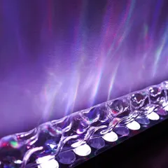 A close-up of the crystal-textured lens on our wall grazer light. This detailed view shows the technology that produces the beautiful, flowing light effects, blending sophisticated engineering with artistic expression.