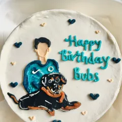 A close-up of the hand-painted pet portrait cake. You can see the detailed layers of buttercream used to create the dog's fur and expression.