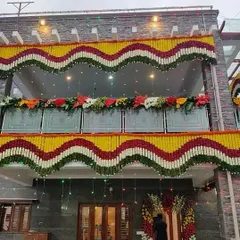 For a grand housewarming, I decorate the entire facade of the house. This design features large, wavy garlands of marigolds and other flowers, making the home look truly celebratory.