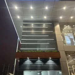 A closer look at the entrance of 'The Sidewalk'. I designed the facade with a combination of dark louvers, a wooden planter box, and bright overhead lighting to create a well-defined and attractive entry point.