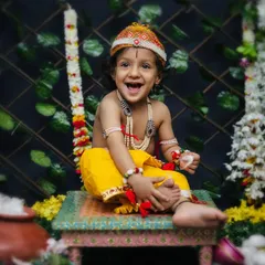 Another joyful moment from our Krishna-themed shoot. The setup with flowers and a pot of 'butter' created the perfect playful environment for these two brothers.