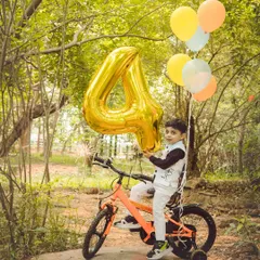 Celebrating a fourth birthday in the great outdoors. Bringing props like bikes and balloons outside makes for a fun and dynamic birthday photoshoot.