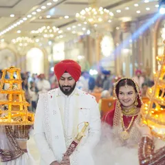 A royal entrance for the couple, flanked by attendants carrying decorative lights. This wide shot captures the grandeur of the moment.