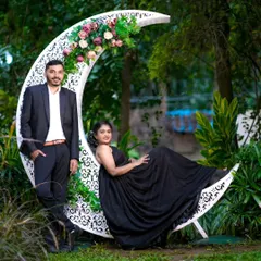 A beautiful maternity moment captured during a couple's photoshoot. The crescent moon prop decorated with flowers adds a touch of magic to this special memory.