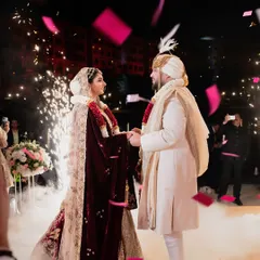 A Varmala exchange filled with emotion and drama. The couple is surrounded by sparks and falling confetti, their faces lit with joy, creating a powerful and unforgettable memory.