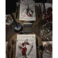 A personalized dinner menu setup with woven placemats, floral napkin rings, and individual table lamps, creating a warm and intimate setting.