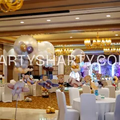 A wide view of a teddy bear themed party, with teddy and airplane centerpieces on each table and large clear balloons creating a dreamy sky effect.