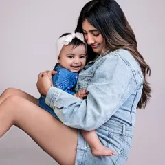 A simple, grounded pose can create a very intimate and relaxed portrait. The matching denim outfits add a cute, coordinated touch to this lovely mother-daughter moment.