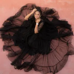 For a truly glamorous and artistic maternity shoot, this black net gown is a showstopper. The voluminous ruffled skirt creates a stunning silhouette from every angle.
