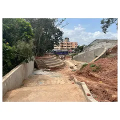 A construction view of the University Sports Center, showing how the structure is nestled into the ground. The design connects to the campus through a series of terraced plazas and steps.