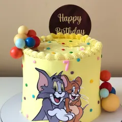 A classic Tom and Jerry cake for a fun-filled birthday. The bright yellow buttercream and colorful polka dots make this design as playful as the iconic duo.