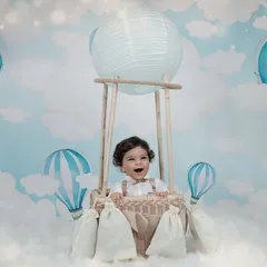 Up, up, and away. Our hot air balloon theme sets the stage for a whimsical adventure, creating magical portraits of your little one floating amongst the clouds in our studio.