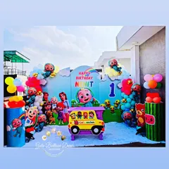 A vibrant Cocomelon themed setup perfect for a toddler's birthday, with all the favorite characters, a school bus prop, and colorful balloon decorations.