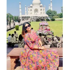 Posing on a bench with the Taj Mahal in the background, this shot showcases my travel outfit and the magnificent monument in one frame.