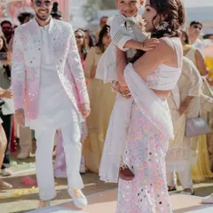It is a special joy to dress an entire family. Here, we designed a coordinated set in white and pastels, with unique floral and mirror work on the father's jacket, the mother's lehenga saree, and the son's matching kurta, ensuring they looked united yet individual.