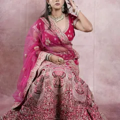 This heavy bridal lehenga in a deep magenta is fit for a queen. The intricate all-over embroidery makes it a showstopper for your wedding day.
