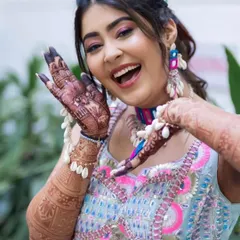 A happy bride showing off her beautiful mehandi. Her smile and the intricate design on her hands are a perfect combination.