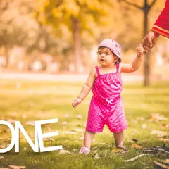 Taking those first tentative steps into year one. For this outdoor first birthday shoot, we used a simple "ONE" prop to mark the occasion while capturing her curiosity in a natural park setting.