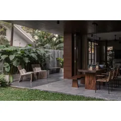 The covered patio at Pràna, designed for year-round enjoyment. We used durable materials like Kota stone and custom wood furniture to create an elegant outdoor dining and seating area that feels connected to the main house.