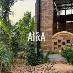 A dry riverbed made of smooth river stones curves around the base of this brick home. This is a functional and aesthetic hardscape solution for drainage that also adds natural texture.