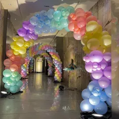 Another view of the pastel rainbow balloon tunnel, showing the scale and immersive effect of the decoration.