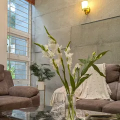 A close-up on the styling details, where a black marble coffee table and fresh flowers add a touch of elegance and life to the room.