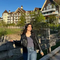 A golden hour shot at Blue Mountain, with the resort architecture in the background. This image showcases a cool, casual outfit against a scenic travel backdrop, ideal for lifestyle or apparel brands.