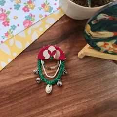 A selection of my Navratri-themed hair brooches and pins. These feature colorful fabric, mirrors, cowrie shells, and even a small bird charm, perfect for adorning a festive bun.
