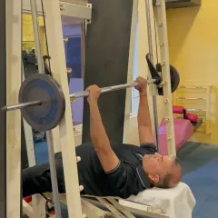 A member performs a bench press on the Smith machine, a great tool for safely lifting heavy weights without a spotter. Our strength equipment is maintained to ensure you can focus on your training, whether you are a beginner or an experienced lifter.