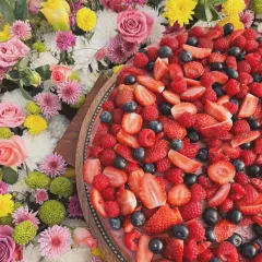 A vibrant mixed berry dessert surrounded by a bed of fresh, colorful flowers. I love creating beautiful displays for family and friends.